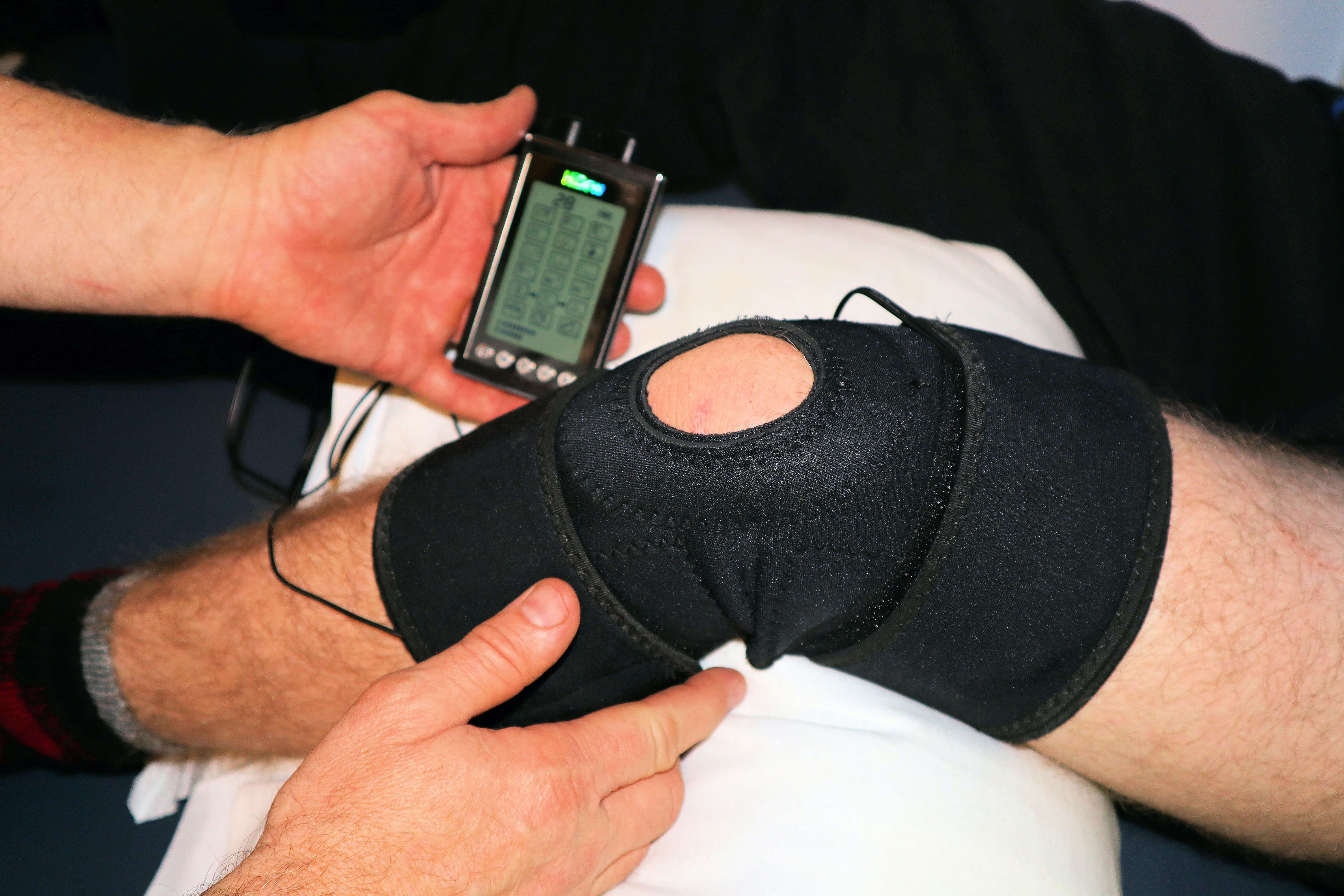 A tens machine being used on a braced knee